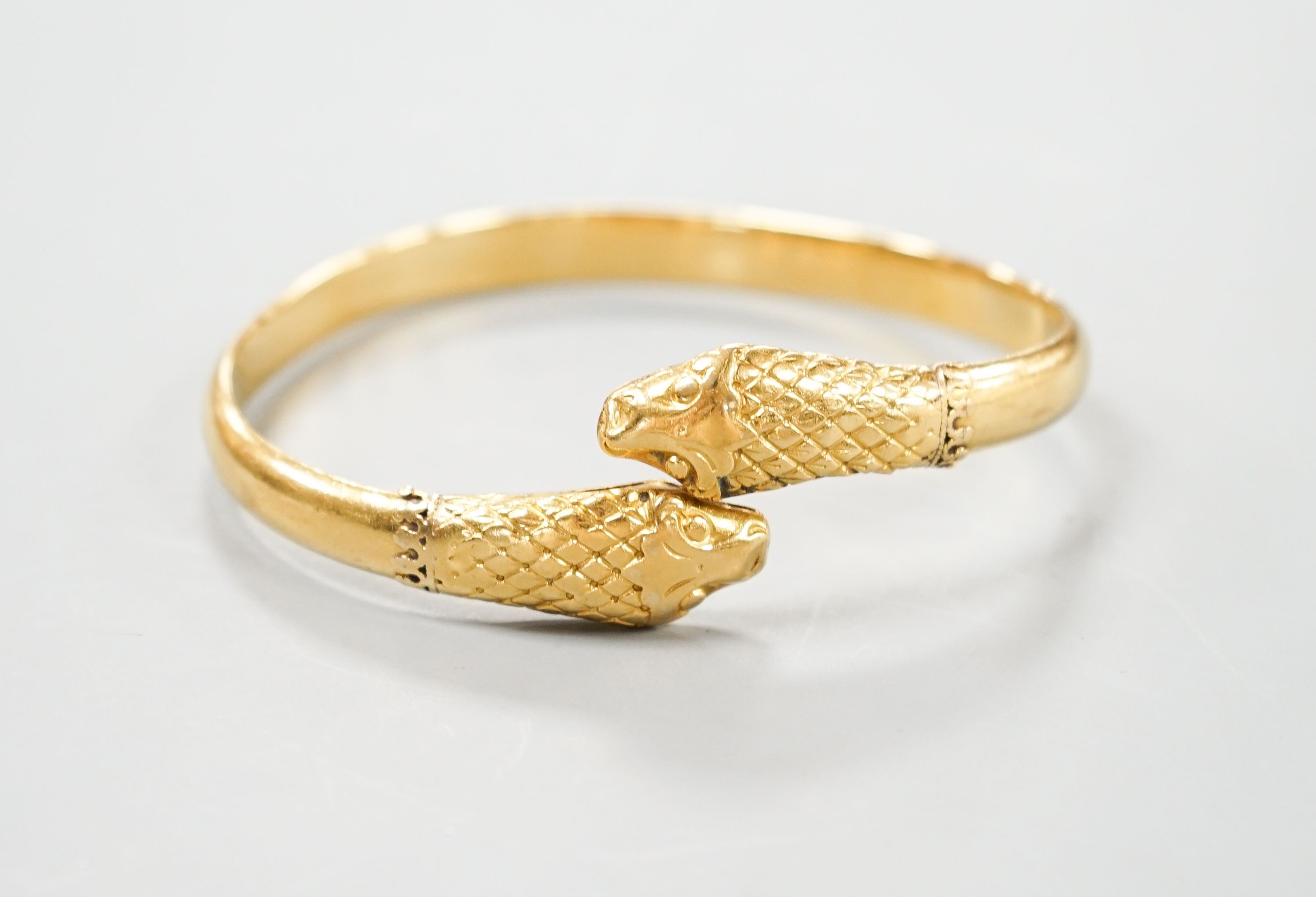 An Indian yellow metal twin headed serpent bangle